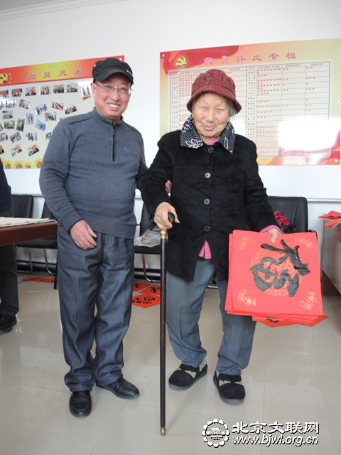 6-80岁大妈拿着福字十分高兴，艺术家把她送到门口的一瞬间（任海濛摄）