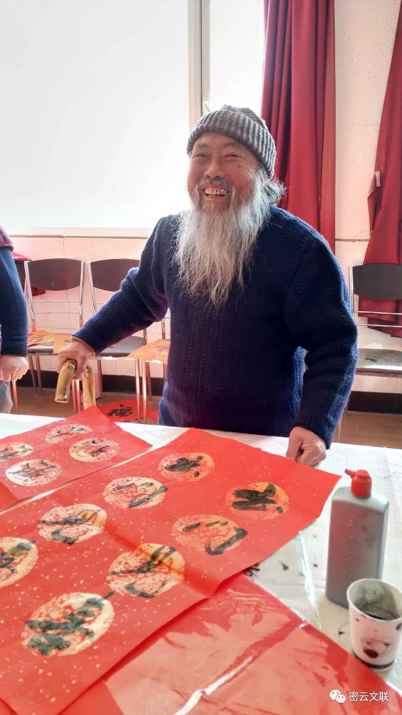 插图3：老大爷拿到书法家书写的春联开心不已