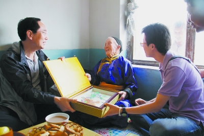 代表团走访牧民家庭，民间艺术家孔炳彰将自己亲手制作的风筝赠送给88岁的老人席日朝老。